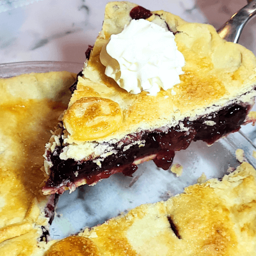 lifting a slice of cherry pie from pan