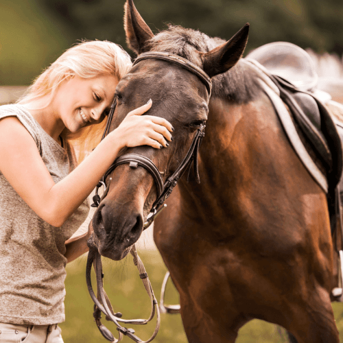 lady with her head next to her horses showing it love