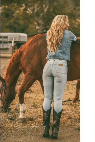 cowgirl wearing with wrangler jeans and a horse