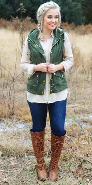 girl wearing a green vest, long sleeve shirt and jeans